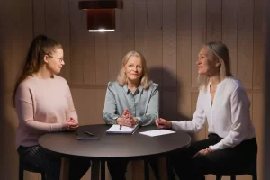 Kolme naista keskustelemassa työpöydän ääressä